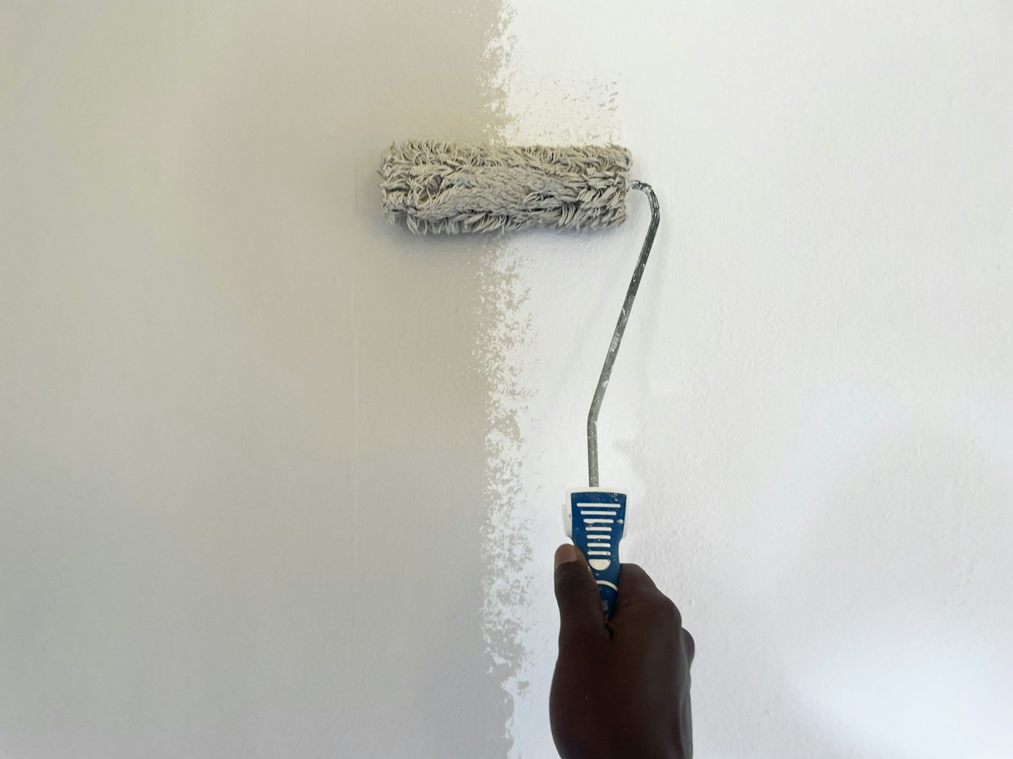 Painter applying vibrant green paint on a wall, transforming the space during a home renovation project and enhancing interior decor